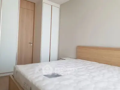 Modern minimalist bedroom with wooden furniture and built-in wardrobe