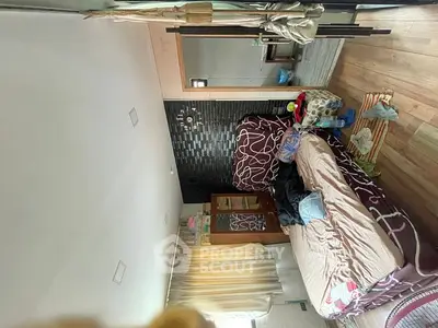 Cozy bedroom with modern decor and wooden flooring, featuring a comfortable bed and ample natural light.