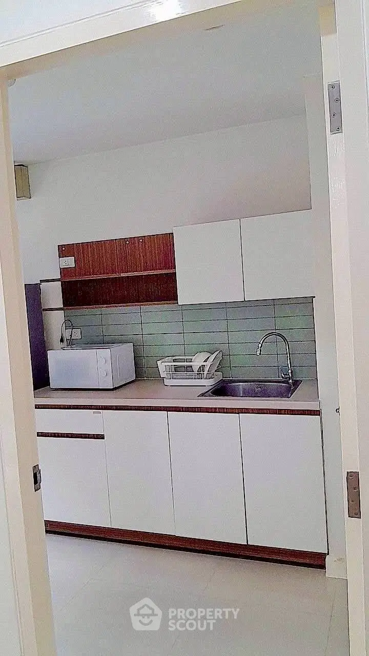Modern kitchen with sleek cabinetry and microwave, ideal for contemporary living.