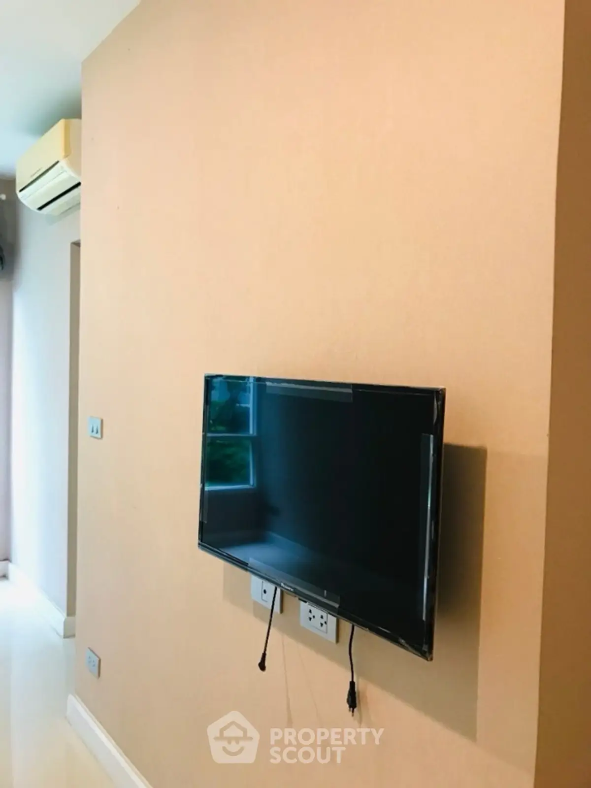 Modern living room with wall-mounted TV and air conditioning unit