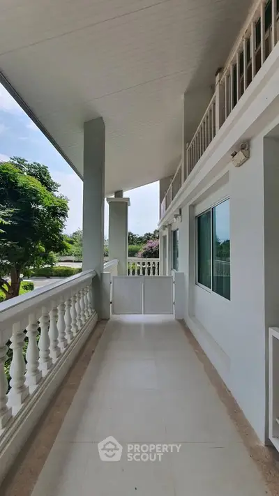 Spacious balcony with elegant railing and lush garden view