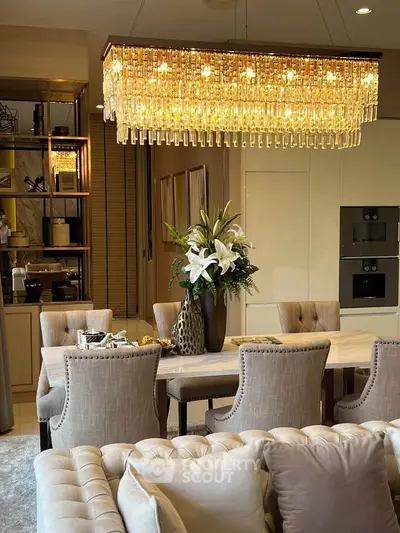 Luxurious dining area with elegant chandelier and plush seating in modern apartment