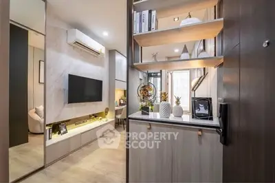 Modern living room with stylish decor and built-in shelving, featuring a sleek TV setup and elegant lighting.