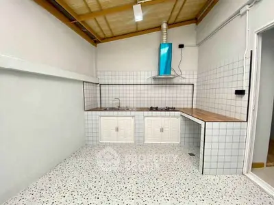 Modern kitchen with tiled walls and gas stove, featuring sleek design and ample counter space.
