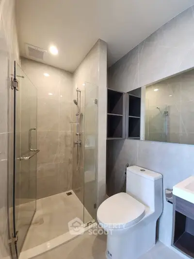 Modern bathroom with glass shower and sleek fixtures in luxury apartment