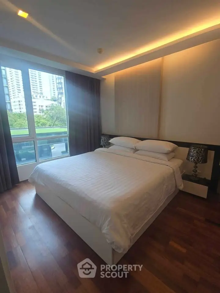 Modern bedroom with large window and stylish decor in urban apartment