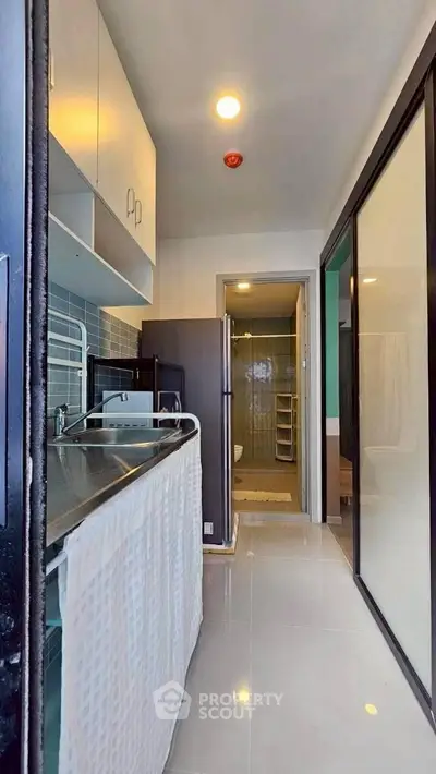 Modern kitchen with sleek design and ample storage in a contemporary apartment.