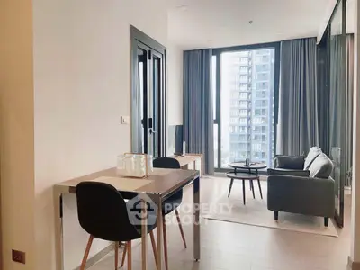Modern living room with large windows and stylish furniture in a high-rise apartment.
