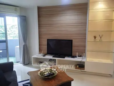 Modern living room with sleek TV unit and balcony access