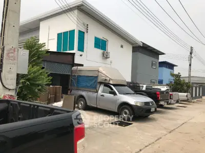 Modern industrial building with parking area and multiple vehicles