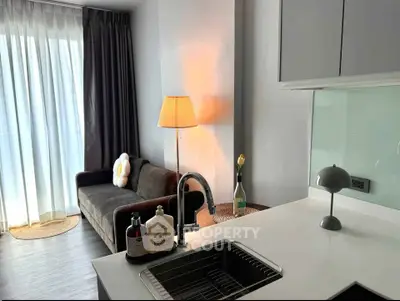 Modern living room with sleek kitchen island and cozy sofa, perfect for urban living.