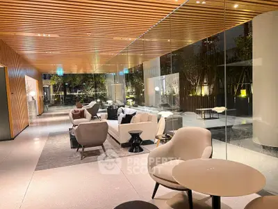 Luxurious modern living room with elegant furniture and glass wall overlooking garden.