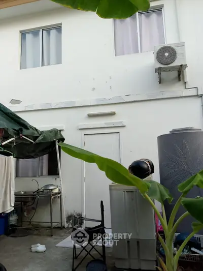 Cozy exterior view of a residential building with outdoor amenities and greenery.
