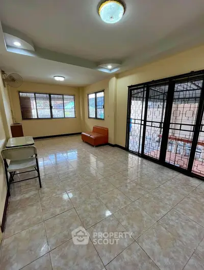 Spacious living room with tiled floor and large windows in a modern apartment.