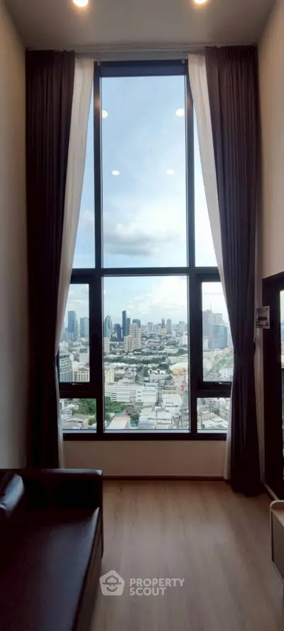 Stunning high-rise apartment with floor-to-ceiling windows offering breathtaking city views.