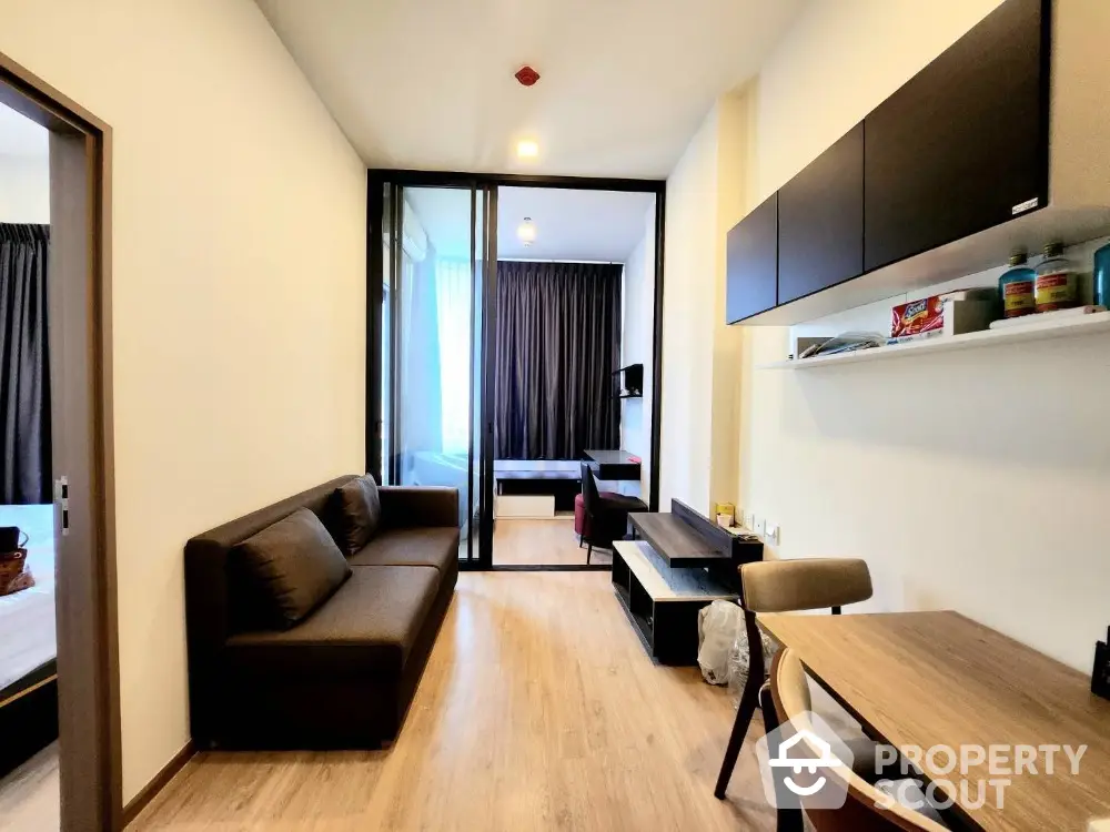 Modern apartment interior with open living room and bedroom, stylish furniture, and natural light.