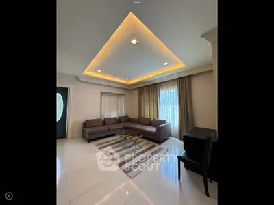 Spacious living room with modern lighting and elegant furniture, perfect for relaxation and entertainment.