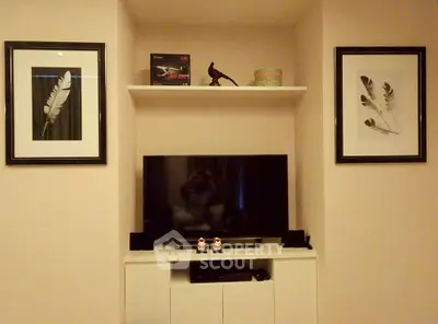 Cozy living room with modern TV setup and stylish wall art, perfect for relaxation and entertainment.