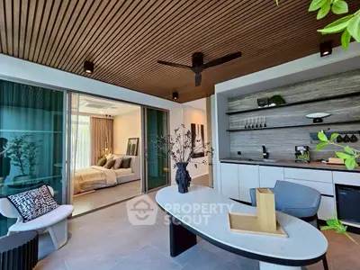 Modern open-layout living room with stylish decor and adjacent bedroom view