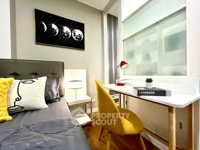 Modern bedroom with stylish decor and cozy workspace, featuring a sleek desk and vibrant yellow chair.
