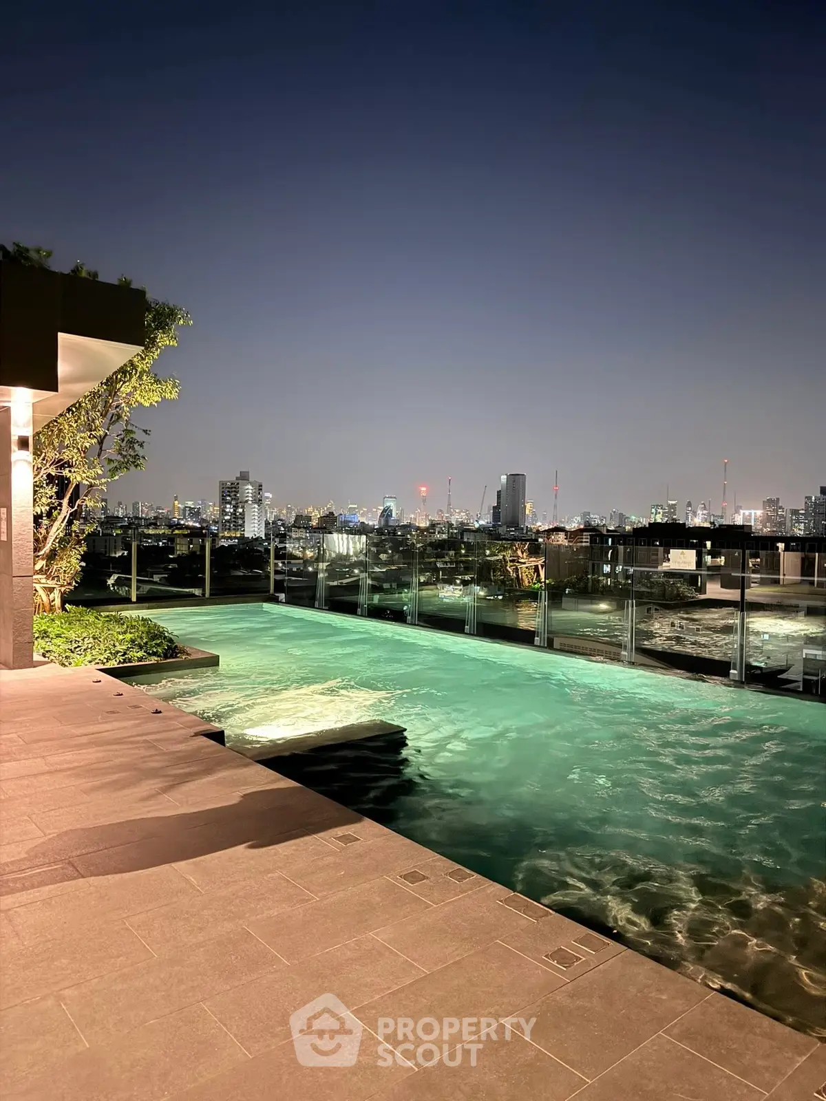 Luxurious rooftop pool with stunning city skyline view at night