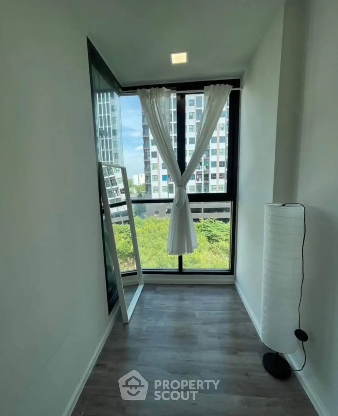 Bright corner unit with floor-to-ceiling windows offering a stunning city view, perfect for a cozy reading nook.