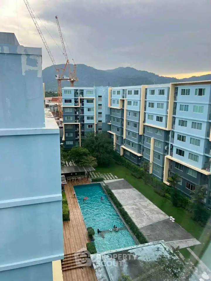 Modern apartment complex with pool and mountain view, ideal for urban living.
