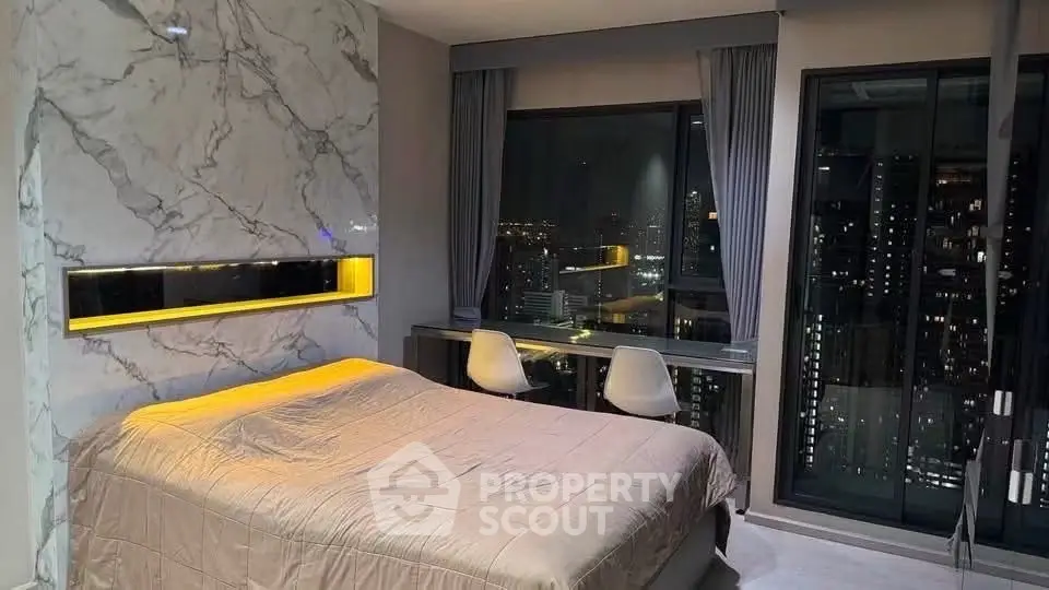 Luxurious bedroom with stunning city view and modern marble accent wall.