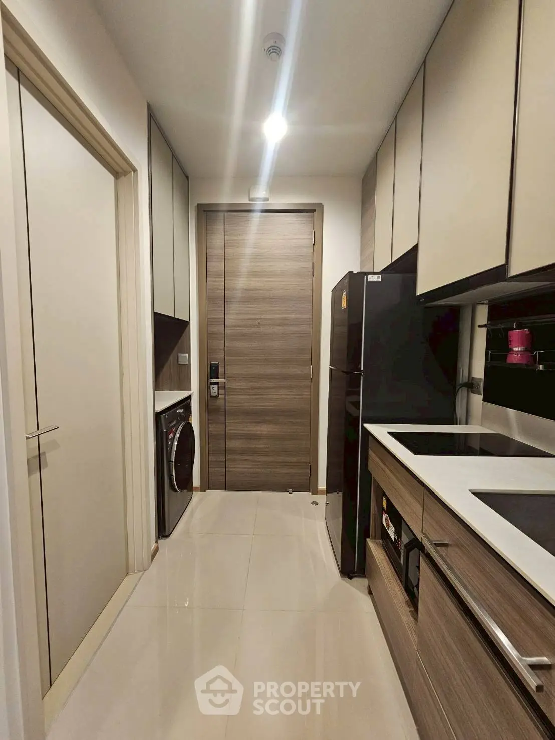 Modern kitchen with sleek cabinetry and integrated appliances in a compact layout.