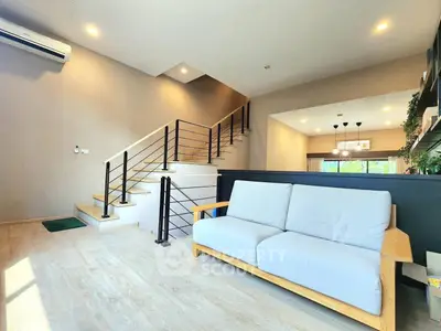 Modern living room with stylish staircase and cozy sofa, perfect for relaxation.