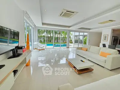 Luxurious living room with pool view, modern furniture, and natural light.