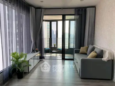 Modern living room with floor-to-ceiling windows and balcony view in a high-rise apartment.