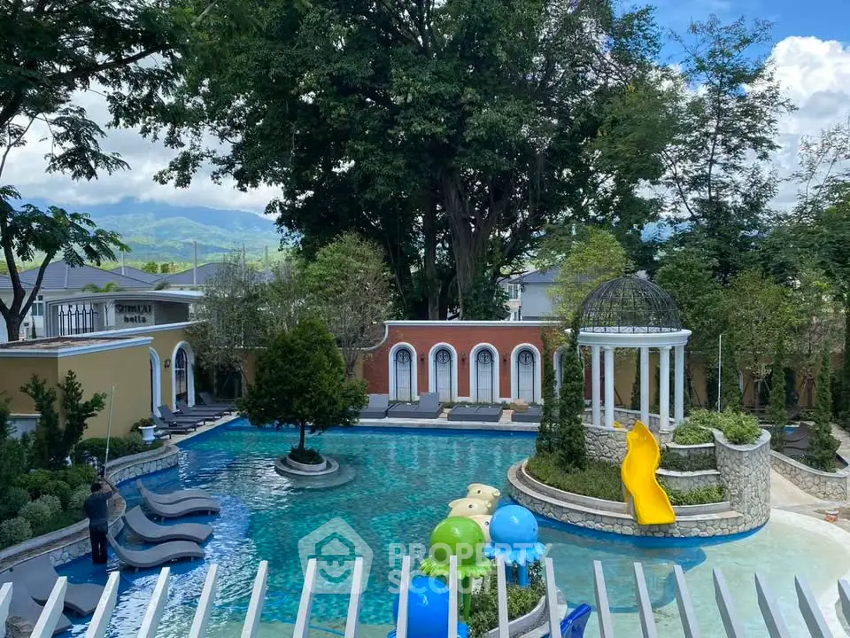 Luxurious outdoor pool area with slides and lush greenery, perfect for family relaxation and entertainment.