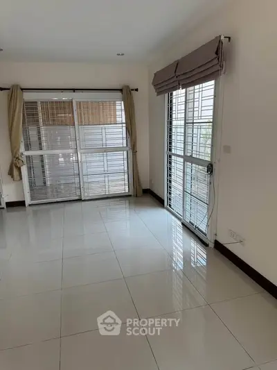 Spacious empty room with large windows and tiled floor, perfect for customization.