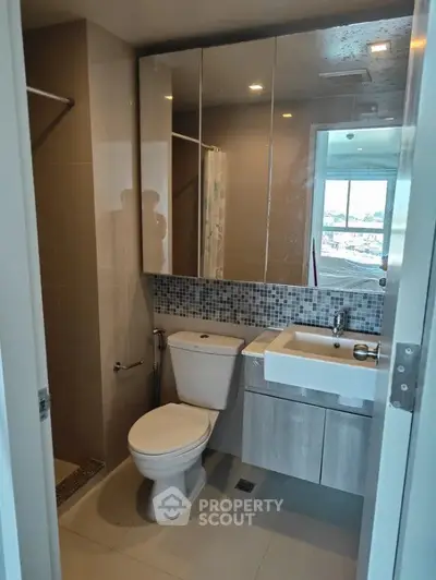 Modern bathroom with sleek fixtures and mirrored cabinets in a contemporary apartment.
