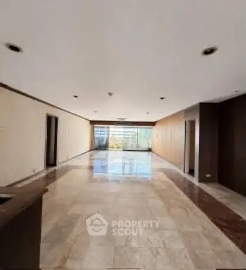 Spacious empty room with marble flooring and large windows