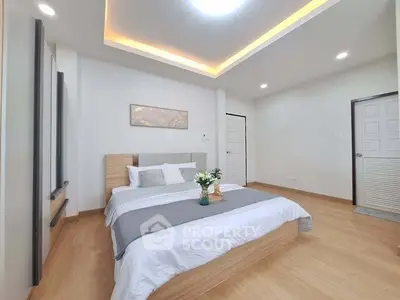 Spacious modern bedroom with elegant lighting and cozy decor