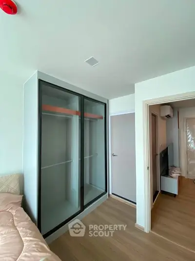 Modern bedroom with sleek wardrobe and wooden flooring in a stylish apartment.