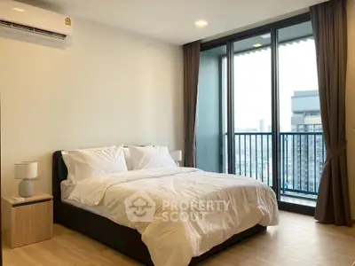 Modern bedroom with city view and balcony access in high-rise apartment