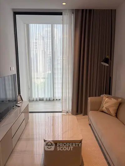 Modern living room with elegant decor and large window offering natural light.