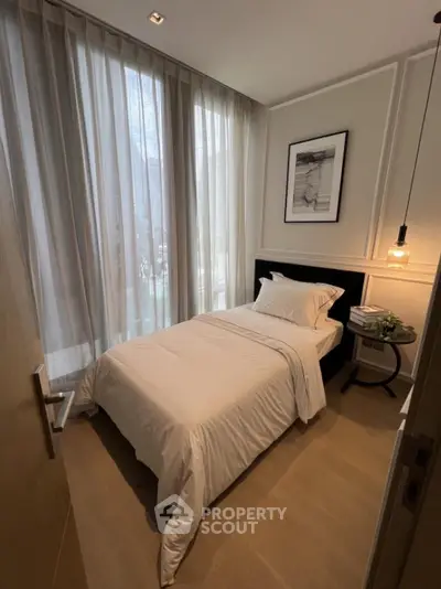 Cozy bedroom with modern decor, featuring a single bed and soft lighting, perfect for relaxation.