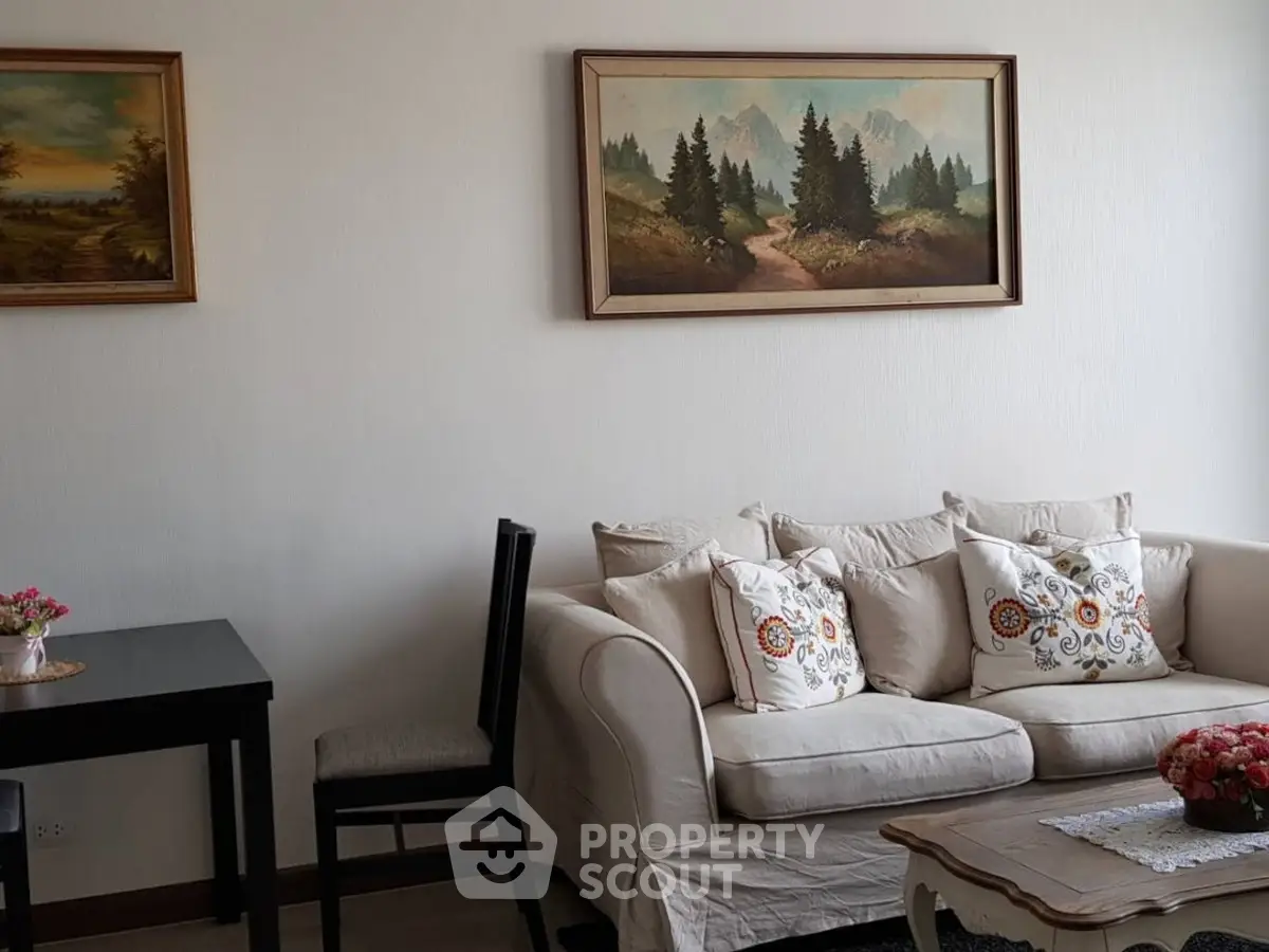 Charming living room with elegant sofa and scenic wall art, perfect for cozy relaxation.