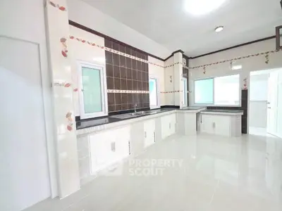 Spacious modern kitchen with sleek countertops and ample storage in a bright, airy setting.