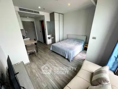 Modern studio apartment with sleek design, featuring a cozy bed, compact kitchen, and stylish living area.