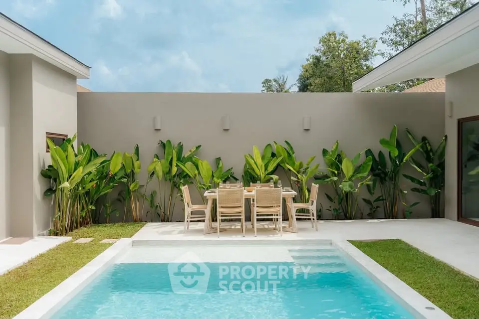 Luxurious private pool area with modern outdoor dining set and lush greenery, perfect for relaxation and entertainment.