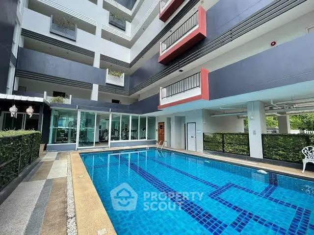 Modern apartment building with a pristine swimming pool and stylish balconies.