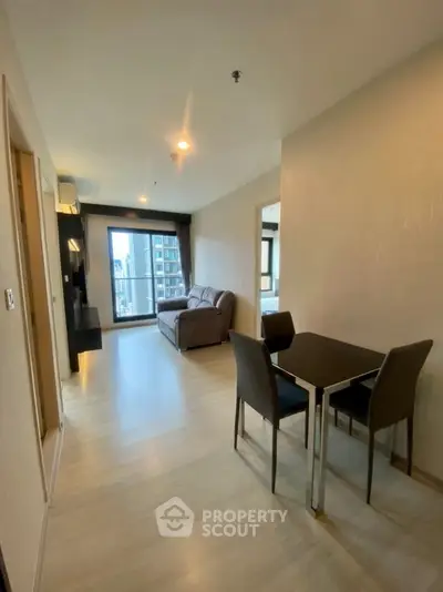 Modern living room with dining area and city view, featuring sleek furniture and natural light.
