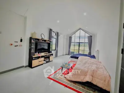 Spacious living room with large windows and modern entertainment center, offering a bright and airy atmosphere.
