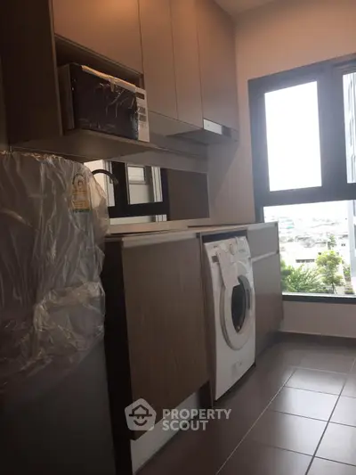 Modern kitchen with washing machine and large window view