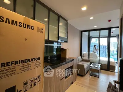 Modern apartment interior with kitchen and living area featuring large windows and city view.
